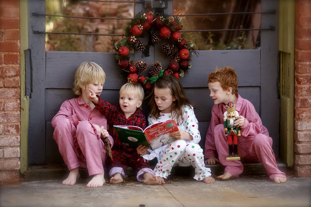 Children sitting outside the door and reading How The Grinch Stole Christmas!