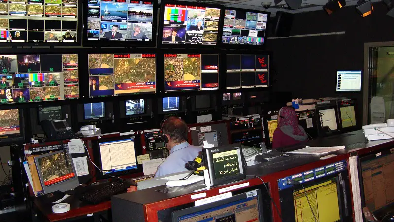A control room with many screens