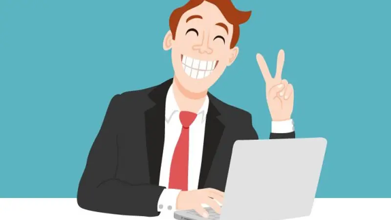A happy employee grinning and showing victory sign while using a laptop.
