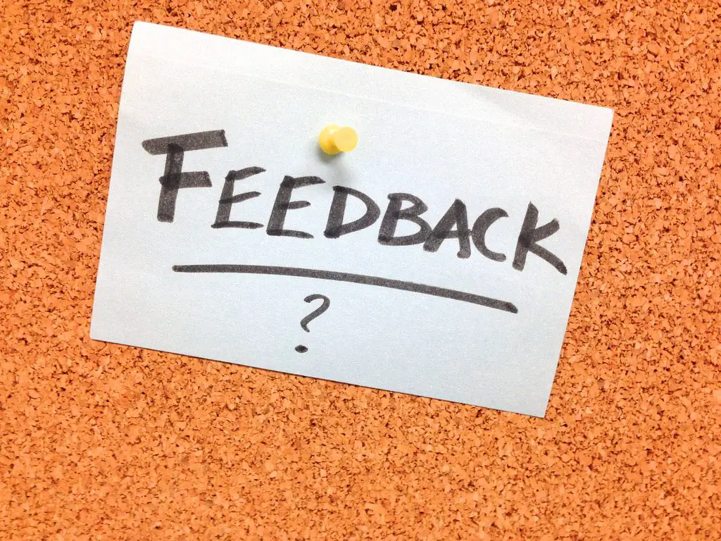 A paper with the word "FEEDBACK" is pinned up on a brown board.